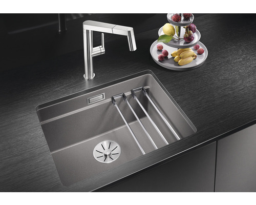 Évier de cuisine avec égouttoir et robinet sur plan de travail foncé