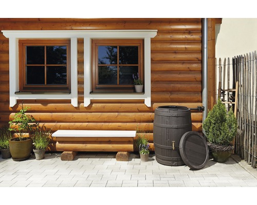 Holzhausfassade mit Fenstern, Bank, Regentonnen und Pflanzen