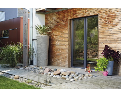 Espace extérieur avec récupérateur d''eau de pluie, mur en bois et douche de jardin.
