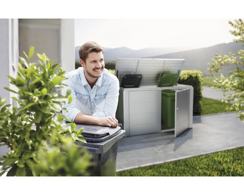 Szene mit einem Mann, der sich an eine Mülltonne lehnt, und einem Mülltonnenbox im Hintergrund.