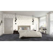 Chambre lumineuse avec lit double, tables de chevet et papier peint fleuri.