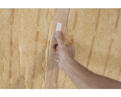 Anbringung von Dämmwolle an einer Holzleiste mit Klebeband