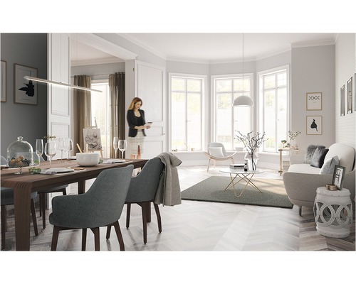 Salon lumineux avec table à manger, chaises, canapé et décorations dans une ambiance conviviale.