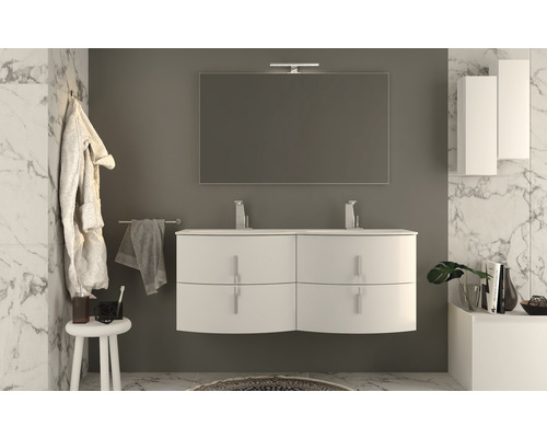 Modernes Badezimmer mit weißem Waschtisch, Spiegel und Badmöbeln vor Marmorwand