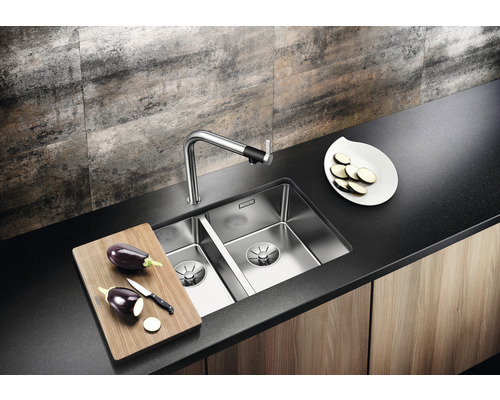 Küchenspüle mit Armatur, Schneidebrett und Aubergine auf einer Arbeitsplatte