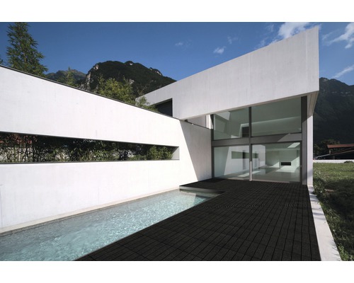 Modernes Haus mit Schwimmbad und dunklem Terrassenboden.