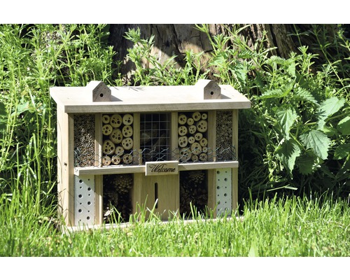 Hôtel à insectes en bois avec différents matériaux de remplissage dans le jardin