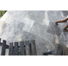 Pose de travertin à l''extérieur avec des chaises en bois