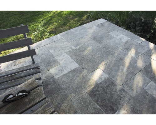 Terrasse mit Travertin Pflastersteinen und Holzbank