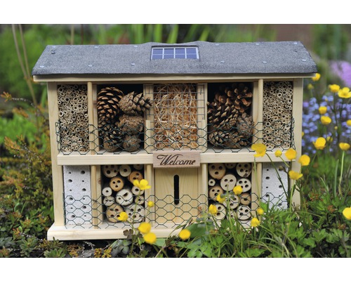 Hôtel à insectes avec différents matériaux de remplissage tels que pommes de pin, bois et paille