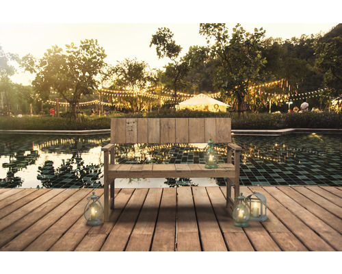 Holzbank mit Laternen am Teich im Garten