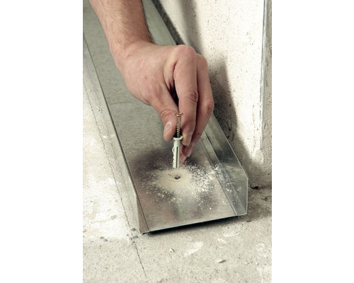 Une main fixe une cheville avec une vis dans un profilé métallique.