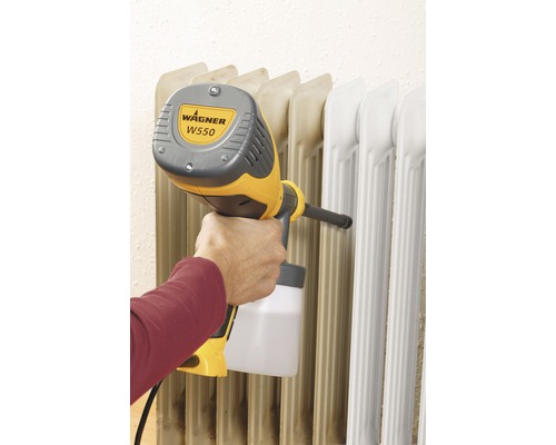 Une personne pulvérise un radiateur avec le système de pulvérisation de peinture Wagner W550.