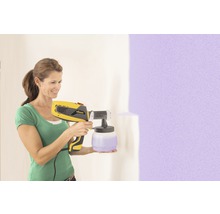Femme utilisant un système de pulvérisation de peinture Wagner pour peindre un mur
