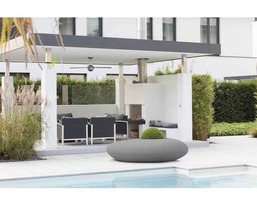 Terrasse couverte avec coin salon, cheminée barbecue et plantations au bord de la piscine