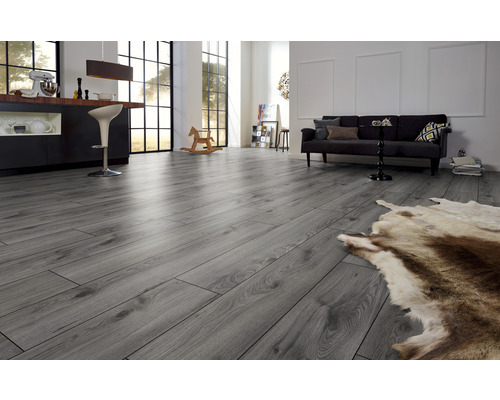 Pièce lumineuse avec sol stratifié gris, canapé et bar