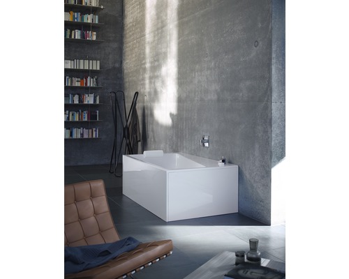 Modernes Badezimmer mit rechteckiger Badewanne, Bücherregal und braunem Sessel