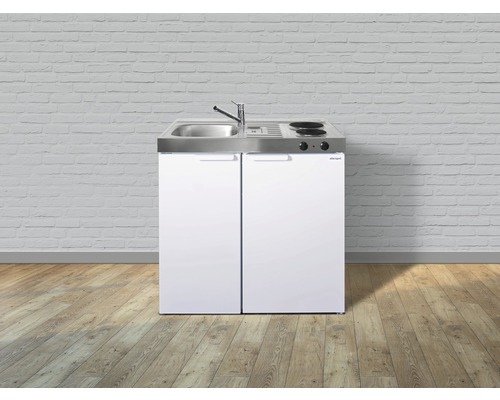 Miniküche mit Spüle, Kochfeld und Kühlschrank vor einer Ziegelwand