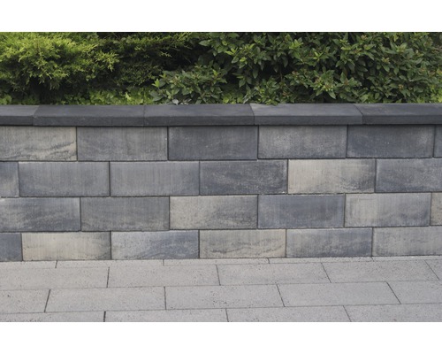 Gestapelte Betonmauersteine mit Abdeckung und Bepflanzung