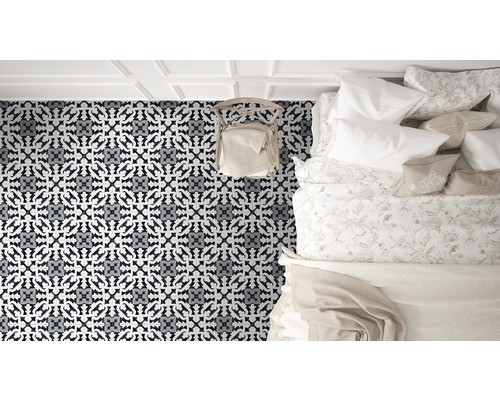 Blick von oben auf ein Schlafzimmer mit gemusterten Fliesen, einem Stuhl und einem Bett