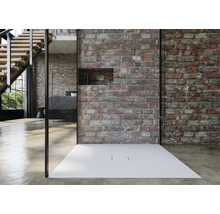 Begehbare Dusche mit flacher, weisser Duschwanne vor einer Backsteinwand