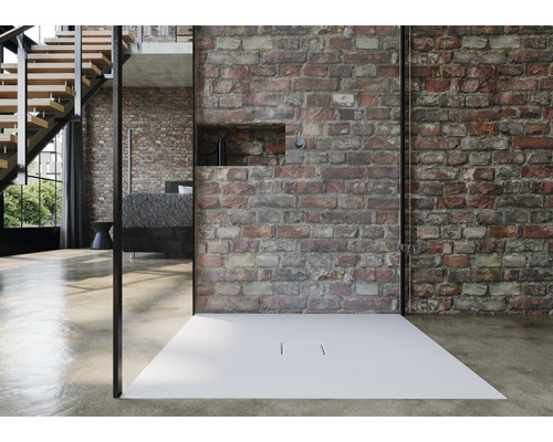 Begehbare Dusche mit flacher, weisser Duschwanne vor einer Backsteinwand