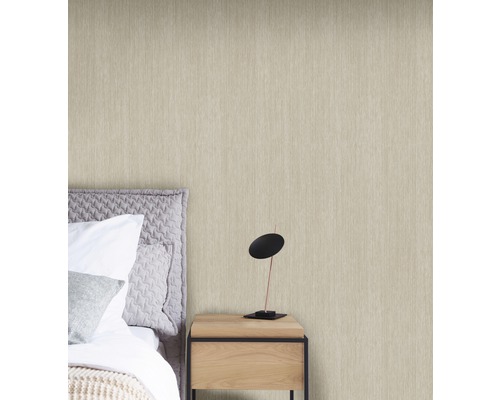Papier peint intissé clair dans une chambre avec lit et table de chevet