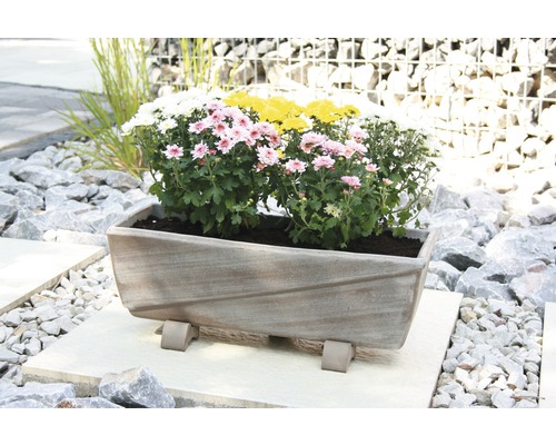 Jardinière rectangulaire avec des fleurs sur un sol en pierre