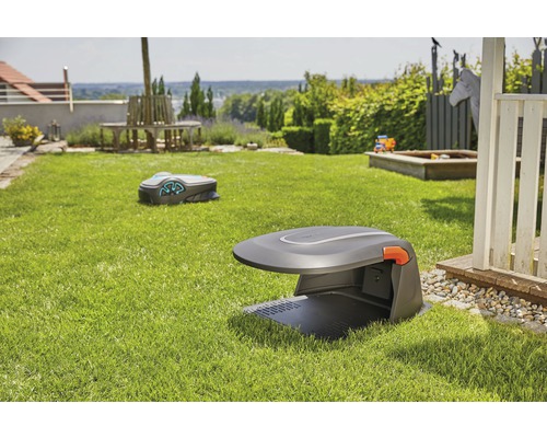 Zwei Rasenmähroboter in einem Garten mit Rasenfläche und Gartenmöbeln.