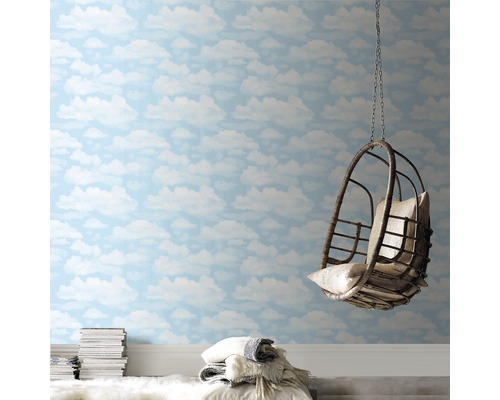 Pièce avec papier peint à motifs de nuages, fauteuil suspendu et pile de livres