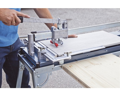 Mann schneidet Fliese mit Fliesenschneider