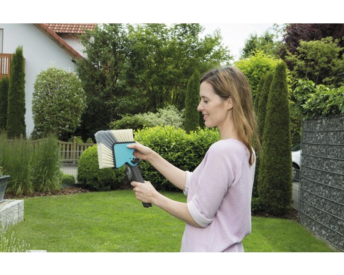 Femme tenant une brosse de lavage dans le jardin