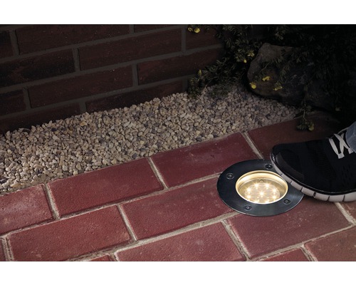 Szene mit Bodeneinbauleuchte, Pflastersteinen und Kies