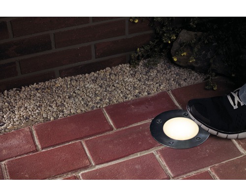 Bodeneinbaustrahler auf rotem Backsteinpflaster mit Kies und Fuß