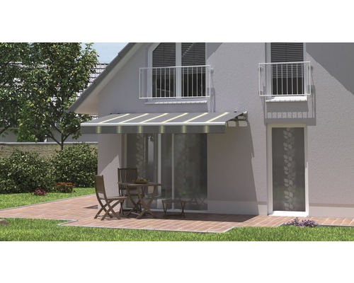 Façade de maison avec store banne au-dessus de la porte de terrasse et coin salon sur la terrasse
