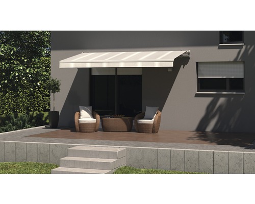 Terrasse avec store, fauteuils en rotin et table devant une maison