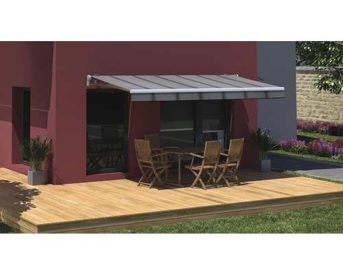 Terrasse avec store, table et chaises devant un mur de maison