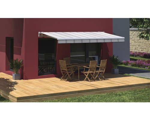 Terrasse avec store, table et chaises devant un mur de maison