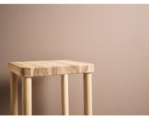 Holzhocker vor einer Wand mit vertikalem Muster