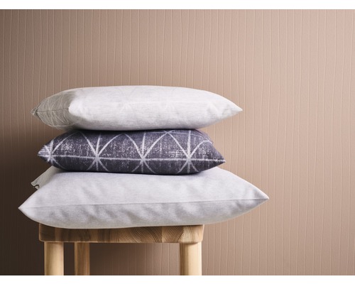 Stapel aus drei Kissen auf einem Hocker