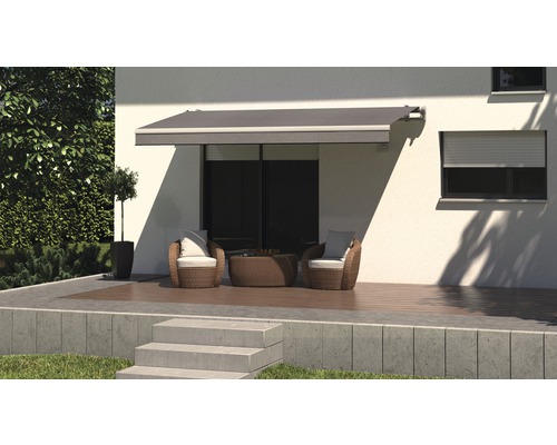 Terrasse avec store, coin salon et volet roulant sur la maison