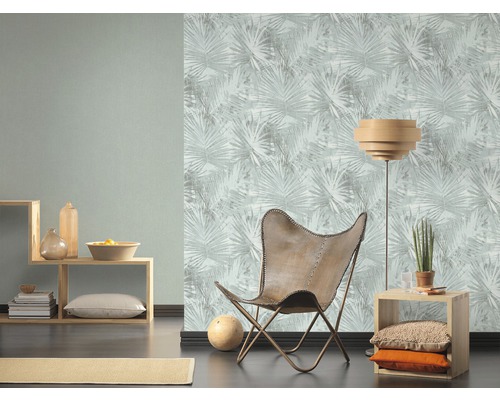 Wohnzimmer mit gemusterter Tapete, Holzregal und Ledersessel