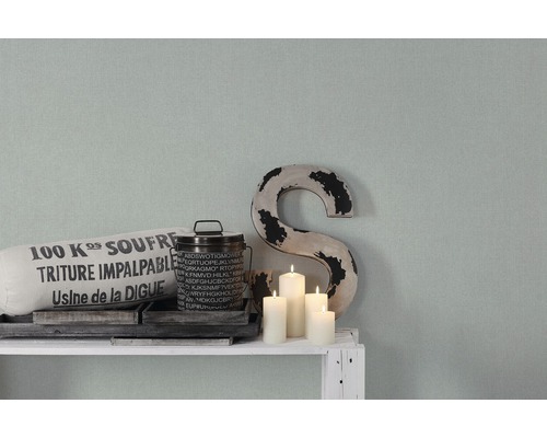 Dekorative Szene mit Kissen, Dose, Kerzen und einem ''S'' auf einem Regal