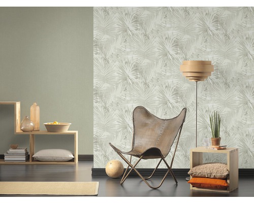 Wohnzimmer mit gemusterter Tapete, Sessel und Regalen.