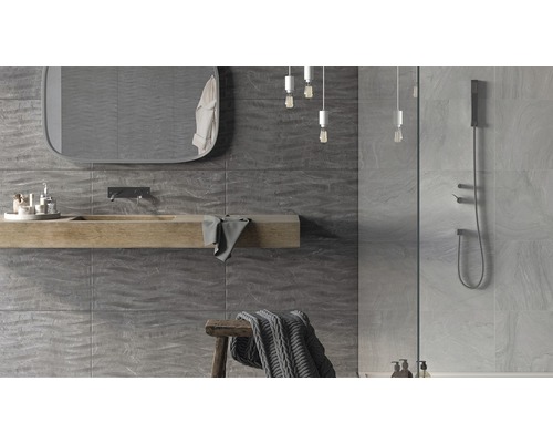 Salle de bains moderne avec carreaux muraux gris, lavabo en bois, miroir et douche.