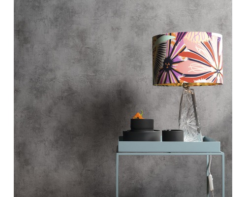 Scène avec une lampe à motifs floraux sur une table d''appoint devant un mur gris