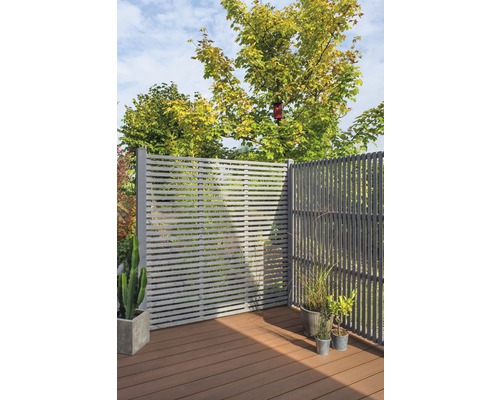 Terrasse mit grauem Sichtschutzzaun, Pflanzen und Holzboden