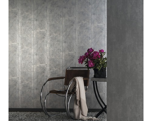 Pièce à vivre avec papier peint gris aspect pierre, fauteuil et table d''appoint avec bouquet de fleurs