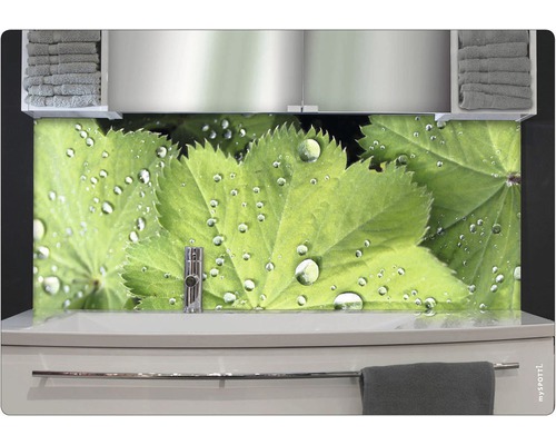 Badezimmer mit Waschbecken, Handtüchern und Wandpaneel mit Blättern und Wassertropfen