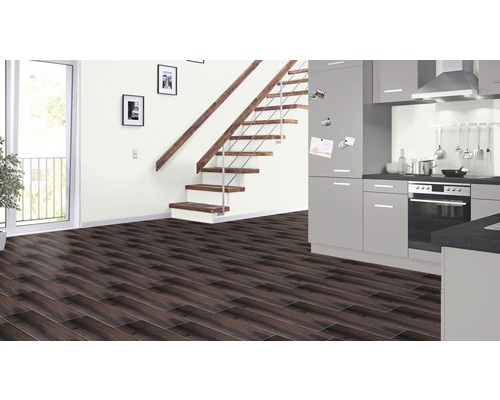 Intérieur moderne avec sol stratifié foncé, escalier avec marches en bois et kitchenette grise.